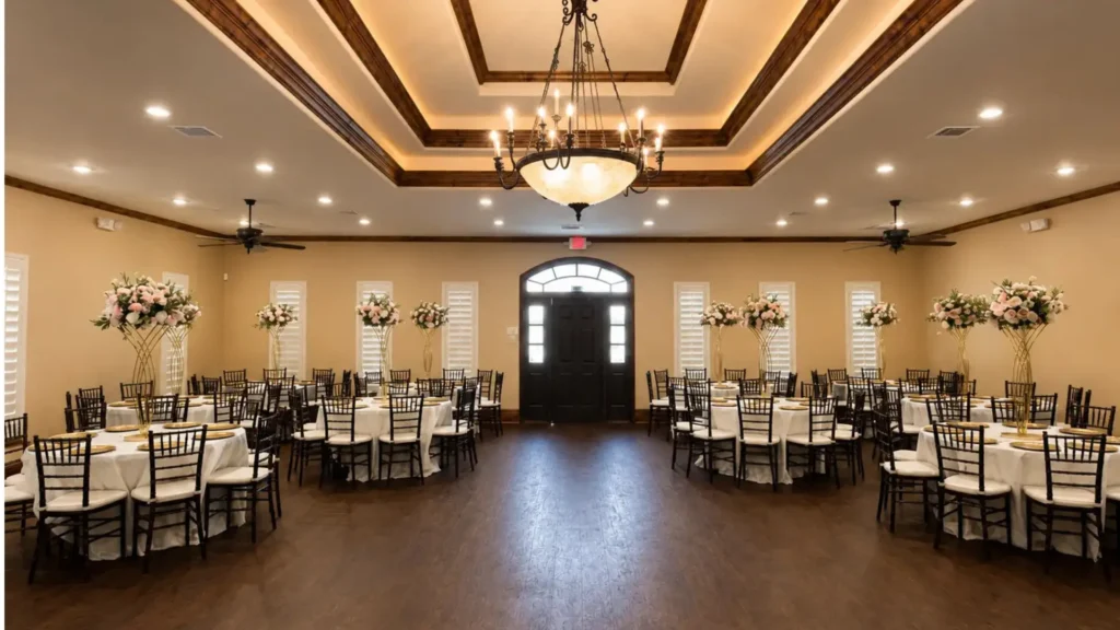 Wide view of The Glitz Plano event venue with guest tables, chairs, chandelier, and open floor layout in Plano TX